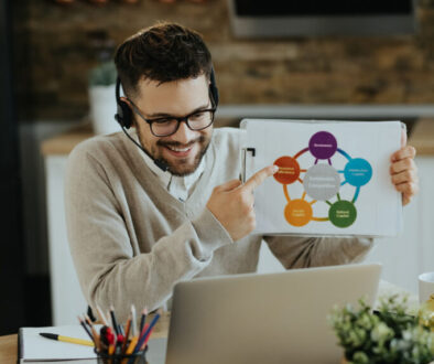 Happy entrepreneur analyzing business chart during web conferenc
