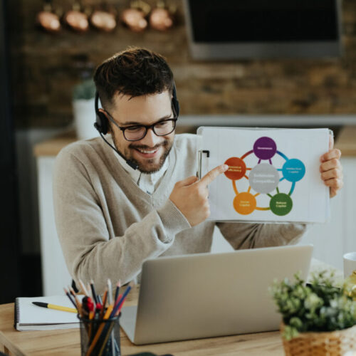Happy entrepreneur analyzing business chart during web conferenc